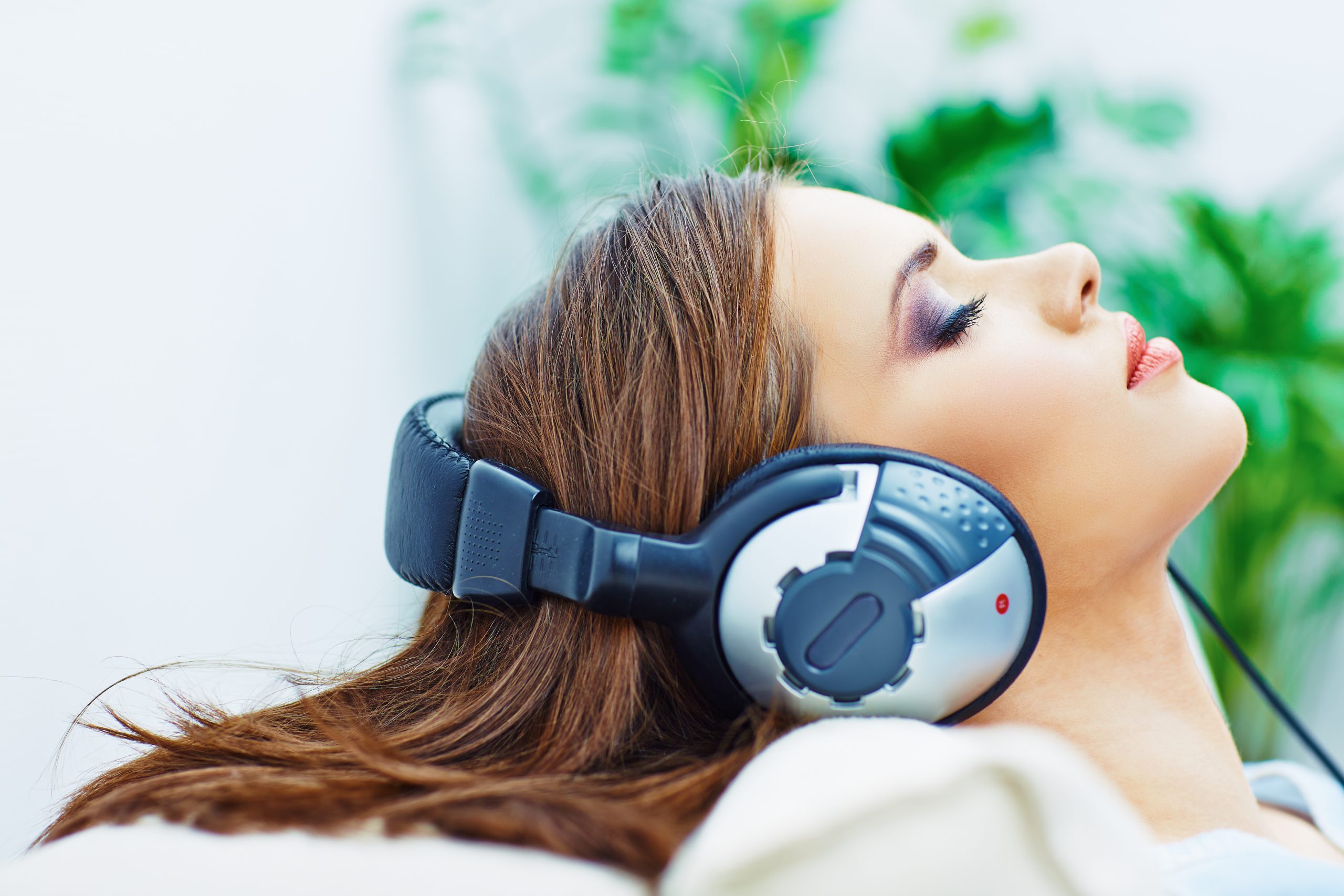 Young woman listening to binaural beats with closed-back headphones.